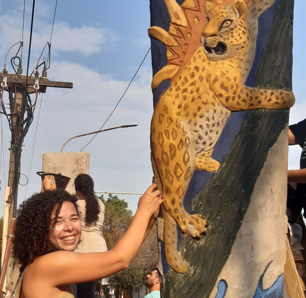 Mujer realiza mural en el Bienal de Muralismo y Arte Público.